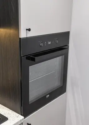 a black oven in a kitchen next to a door at Apartments in Vilnius in Vilnius