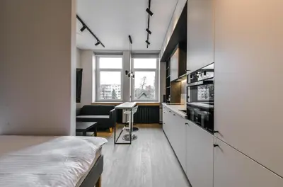 a room with a bed and a kitchen with a table at Apartments in Vilnius in Vilnius