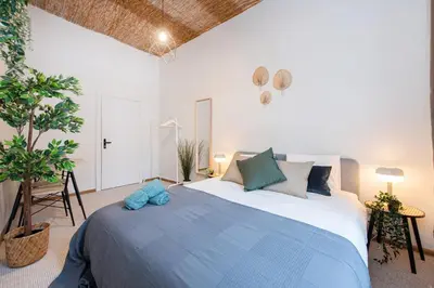 a bedroom with a large bed with blue pillows at Bali house Vilnius in Vilnius