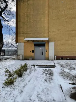a building with a door in the snow at 30 Airport apartment in Vilnius