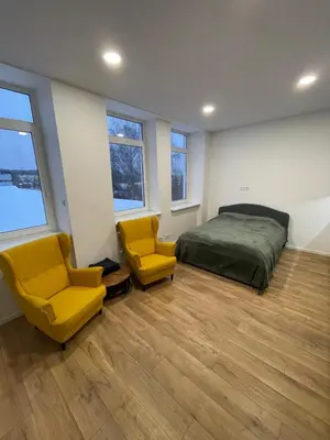 a bedroom with a bed and two yellow chairs at 30 Airport apartment in Vilnius