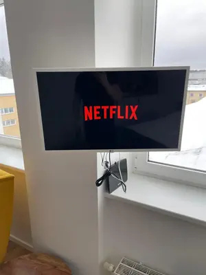 a monitor in a window with the netflix sign on it at 30 Airport apartment in Vilnius