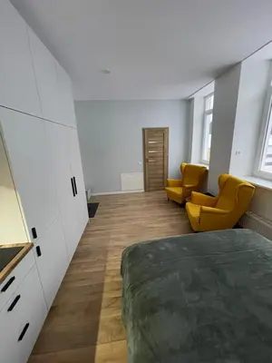 a bedroom with a bed and two yellow chairs at 30 Airport apartment in Vilnius