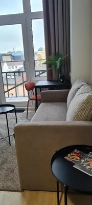 a living room with a couch and a large window at Stay in Kaunas & LA51 Loft - Free Parking in Kaunas