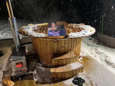 a woman is in a hot tub in a wooden building at Villa Arjola in Kaltanėnai
