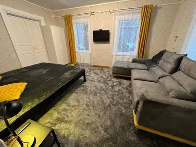 a living room with a couch and a couch and a bed at Villa Arjola in Kaltanėnai