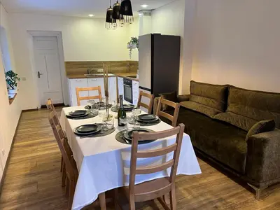 a living room with a table and a couch at Villa Arjola in Kaltanėnai