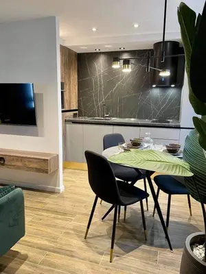 a dining room with a table and chairs and a kitchen at Siauliai ‘Four sisters’ in Šiauliai