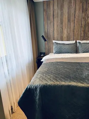 a bedroom with a bed with a wooden headboard at Siauliai ‘Four sisters’ in Šiauliai
