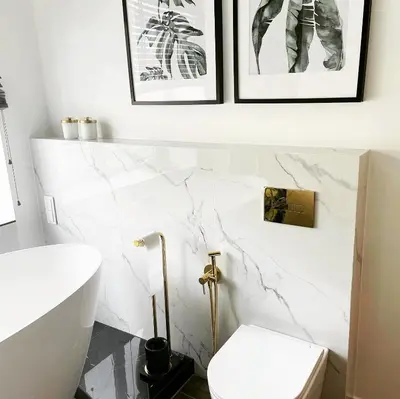 a bathroom with white marble walls and a toilet at Siauliai ‘Four sisters’ in Šiauliai