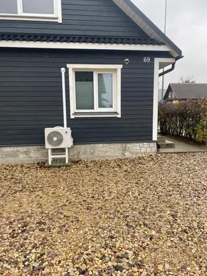 a black house with a fan sitting outside of it at Trumpalaikė Nuoma-Apgyvendinimas in Rokiškis