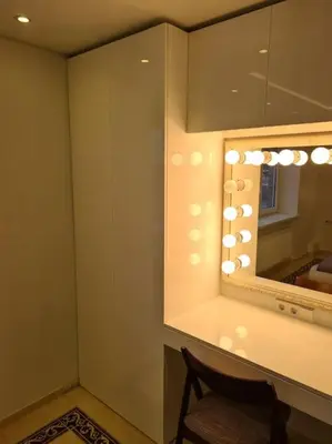 a bathroom with a mirror and a chair next to a counter at River view appartment in Kaunas in Kaunas