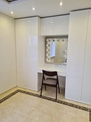 a chair sitting in a room with white cabinets at River view appartment in Kaunas in Kaunas