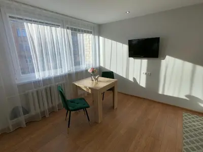 a room with a table and two chairs and a television at Stay in center #Šiauliai in Šiauliai