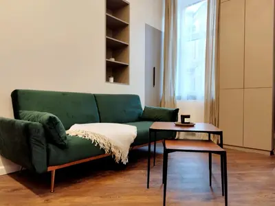 a living room with a green couch and a table at Stylish Central Station Old Town Apart FREE PARKING in Vilnius
