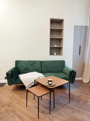 a green couch in a living room with a coffee table at Stylish Central Station Old Town Apart FREE PARKING in Vilnius