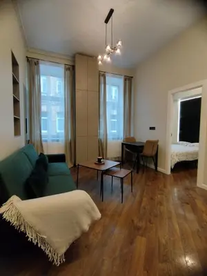 a living room with a green couch and a table at Stylish Central Station Old Town Apart FREE PARKING in Vilnius