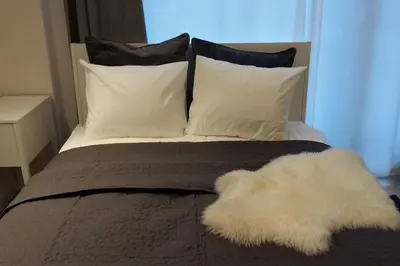a bed with two pillows and a white blanket at Studio Mindaugas in Vilnius