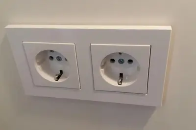 two white electrical switches on a white wall at Studio Mindaugas in Vilnius