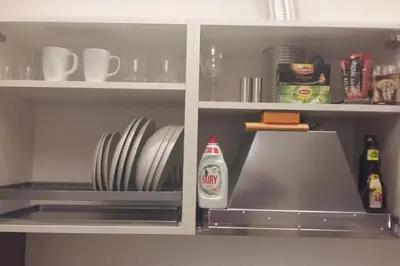 a kitchen cabinet filled with plates and dishes at Studio Mindaugas in Vilnius
