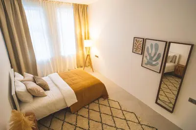 a bedroom with a bed and a large window at Old Town Apartment in Kaunas