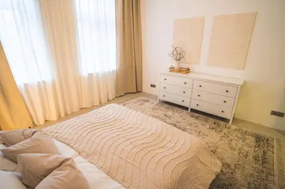 a bedroom with a bed and a dresser and a window at Old Town Apartment in Kaunas