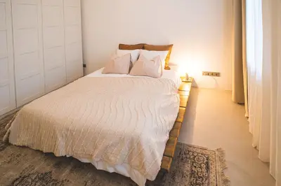 a bedroom with a large bed with white sheets and pillows at Old Town Apartment in Kaunas