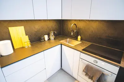 a kitchen with white cabinets and a sink at Old Town Apartment in Kaunas