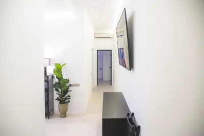 a hallway with white walls and a black table and a plant at Old Town Apartment in Kaunas
