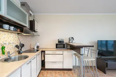 a kitchen with white cabinets and a sink and a counter at Lovely city panorama apartment by Polo Apartments in Kaunas