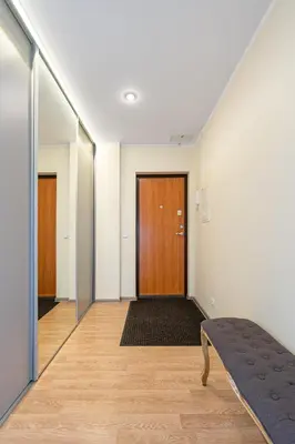 an empty hallway with a wooden door and a bench at Lovely city panorama apartment by Polo Apartments in Kaunas