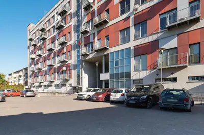a parking lot with cars parked in front of a building at Lovely city panorama apartment by Polo Apartments in Kaunas
