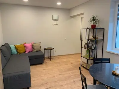 a living room with a couch and a table at Cozy apartment in Karmelava in Karmėlava