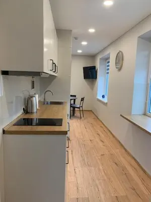 a kitchen with a sink and a wooden floor at Cozy apartment in Karmelava in Karmėlava
