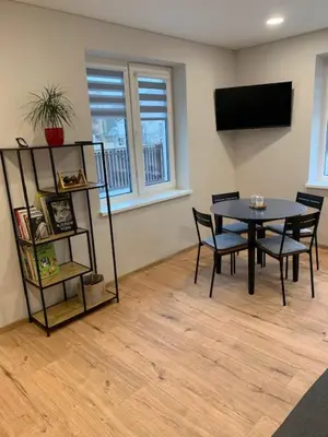 a dining room with a table and chairs and a television at Cozy apartment in Karmelava in Karmėlava