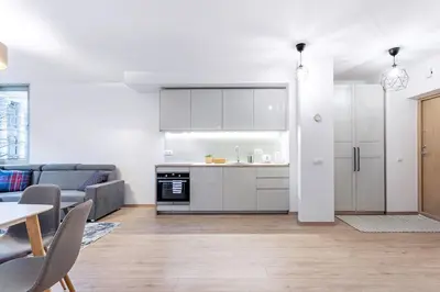 a kitchen and living room with a couch and a table at Business Apartment In Jaksto Street in Vilnius