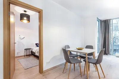 a mirror in a dining room with a table and chairs at Business Apartment In Jaksto Street in Vilnius