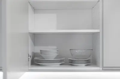 a white cabinet with plates and bowls in it at Business Apartment In Jaksto Street in Vilnius