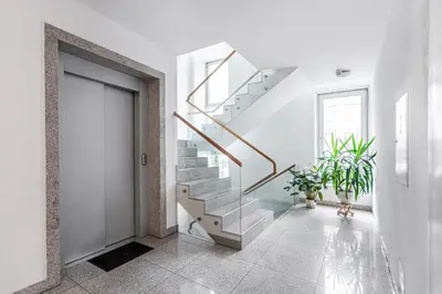 a staircase in a white room with plants at Business Apartment In Jaksto Street in Vilnius