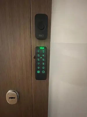 a remote control on a door with a green light at Ukmergė Apartments in Ukmergė