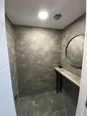 a bathroom with a large shower with a mirror at Ukmergė Apartments in Ukmergė