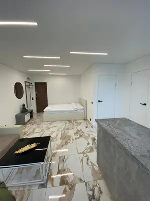 a white room with a bed and a marble floor at Ukmergė Apartments in Ukmergė