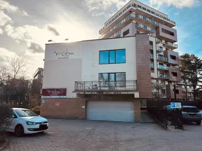 a building with a car parked in front of it at Liepu Apartments Druskininkai in Druskininkai