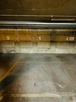 an empty parking garage with a concrete wall at Liepu Apartments Druskininkai in Druskininkai