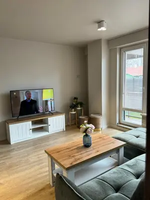 a living room with a tv and a coffee table at Liepu Apartments Druskininkai in Druskininkai