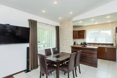 a kitchen with a table and chairs and a television at 3-bedroom villa surrounded by beautiful nature in Vaišvydava