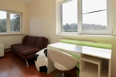 a office with a desk and a chair and a couch at 3-bedroom villa surrounded by beautiful nature in Vaišvydava