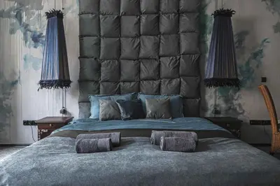 a bedroom with a large bed with a large headboard at Luxuriuos flat in the capital's old town in Vilnius