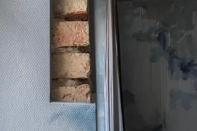 a brick wall next to a door with a mirror at Luxuriuos flat in the capital's old town in Vilnius