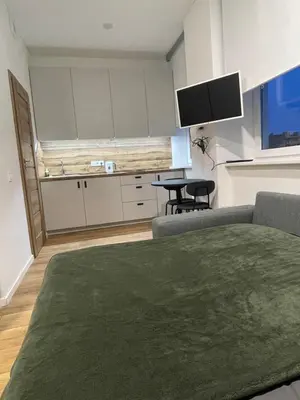 a living room with a couch and a table and a tv at 32 Airport Apartment in Vilnius